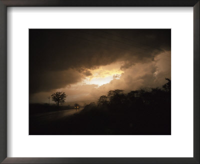 Car Travels A Lonesome Road With A Storm Approaching by David Evans Pricing Limited Edition Print image