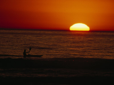 Silhouetted Kayaker Paddles In The Pacific Ocean At Sunset by Tom Murphy Pricing Limited Edition Print image
