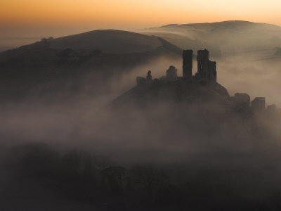 Sea Of Mist Swirls Around The Base Of Corfe Castle At Dawn, Corfe, Dorset, United Kingdom by Adam Burton Pricing Limited Edition Print image