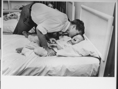 Bobby Kennedy Kissing His Pajama Clad Squealing Young Son by Paul Schutzer Pricing Limited Edition Print image