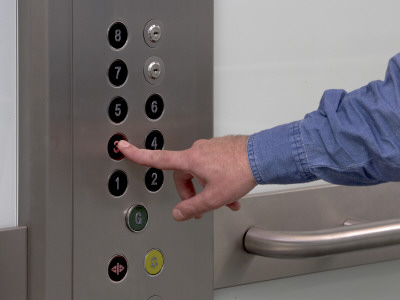 Office Life And Interiors Part Two, Man Pressing Lift Buttons by Richard Bryant Pricing Limited Edition Print image