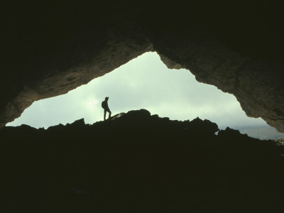 Potholer Silhouetted At Exit To Underground Cave System, Huesco, Spain by Inaki Relanzon Pricing Limited Edition Print image