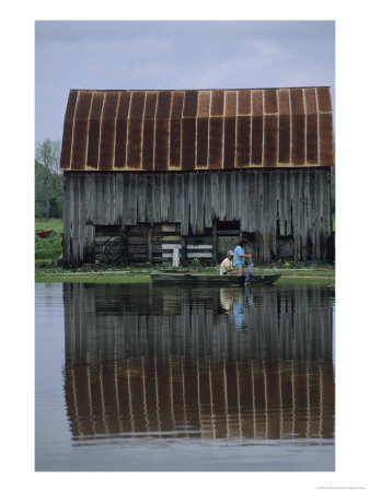 A Family Travels By Rowboat Through Flood Waters After Heavy Rains by Joel Sartore Pricing Limited Edition Print image