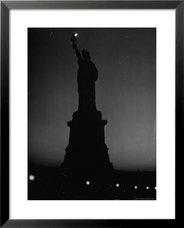 Silhouette Of Statue Of Liberty Lit By Two 200 Watt Lamps During Wartime Effort To Conserve Energy by Andreas Feininger Pricing Limited Edition Print image