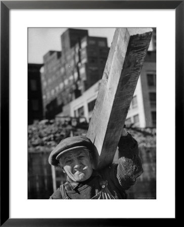 Construction Worker Carrying A Piece Of Wood by Cornell Capa Pricing Limited Edition Print image