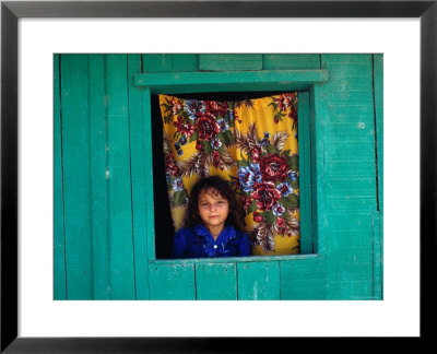 Little Girl In The Window Of Her Brightly Painted House, Ciudad Melchor De Mencos, Guatemala by Jeffrey Becom Pricing Limited Edition Print image