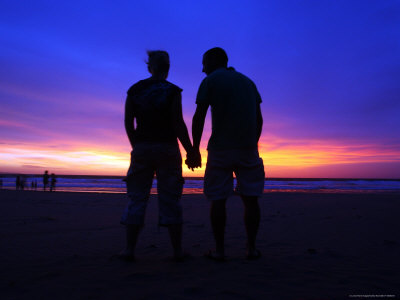 Silhouette Of A Couple Holding Hands At Sunset by Andrew Brownbill Pricing Limited Edition Print image