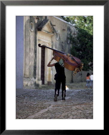 Musician Carrying Double Bass Along Cobbled Street To Plaza Mayor, Trinidad, Cuba by Lee Frost Pricing Limited Edition Print image
