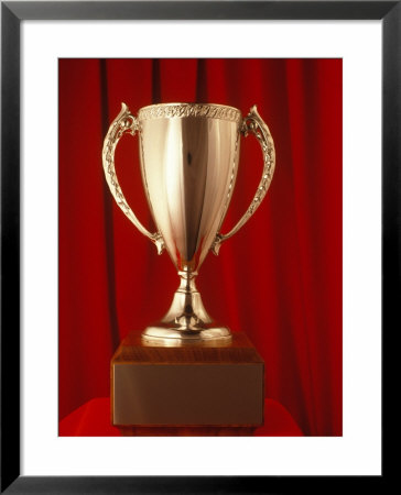 Gold Trophy On Wooden Base In Front Of Red Velvet by Nancy Garbarini Pricing Limited Edition Print image