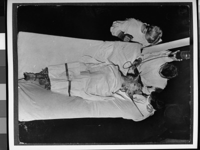 Masked Doctors Giving Blood Transfusion To Goat, Exposed To A-Bomb Blast Radiation On Bikini Atoll by George Skadding Pricing Limited Edition Print image