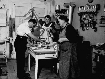 Czech Pro-Nazi Family Making String Of Swastika Pennants To Welcome Hitler's Occupying Troops by John Phillips Pricing Limited Edition Print image