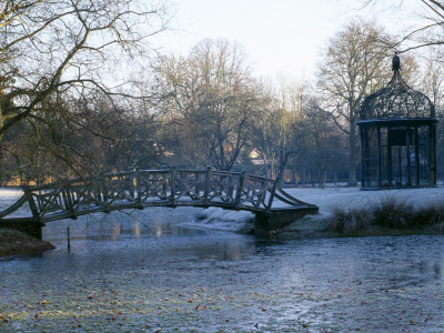 Ornamental Bird Cage And Bridge Beside Lake In Neo-Classical Park Garden, Designer: Quinlan Terry by Clive Nichols Pricing Limited Edition Print image