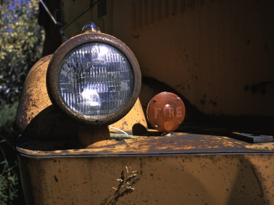 Front Light Of An Orange Truck At A Car Cemetery In Colorado by Michael Brown Pricing Limited Edition Print image
