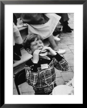 Hollywood Child Timmy Garry At Children's Party Dressed In Cowboy Outfit Eating A Hamburger by J. R. Eyerman Pricing Limited Edition Print image