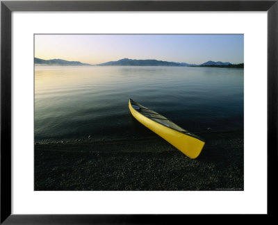 Yellow Canoe On The Shore Of A Calm Body Of Water by Michael Melford Pricing Limited Edition Print image