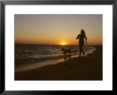 Woman And Her Dog Running Along Currituck Sound Beach At Sunset, Nags Head, North Carolina by Skip Brown Pricing Limited Edition Print image