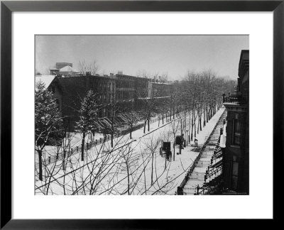 Woman Sweeps Snow Off A Snow-Covered Street Lined With Brownstones Near Two Horse-Drawn Buggies. by George B. Brainerd Pricing Limited Edition Print image