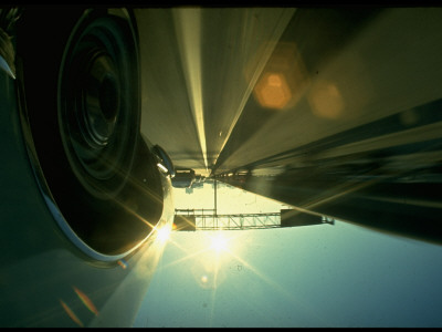 Sun Glinting Into Camera With Car Wheel In Fore On Highway, Illustrating Dangerous Road Situations by Ralph Crane Pricing Limited Edition Print image