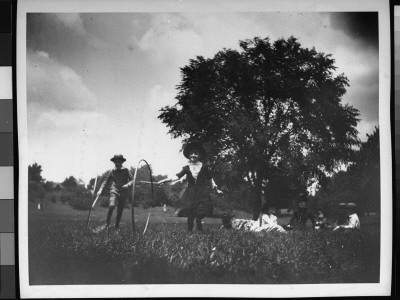 Edie Swan And Harry Dwight Rolling Hoops In A Field As Other Children Look On In Background by Wallace G. Levison Pricing Limited Edition Print image