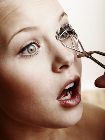 Close-Up Of A Young Woman Using An Eyelash Curler by Atli Mar Pricing Limited Edition Print image