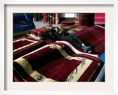 A Masked Boy Rests At A Carpet Shop In Kabul, Afghanistan, Friday, September 22, 2006 by Rodrigo Abd Pricing Limited Edition Print image