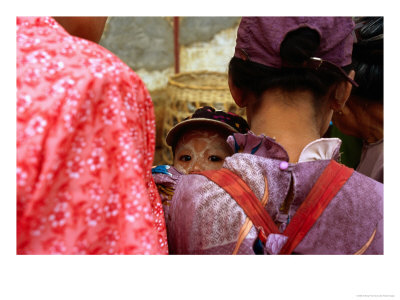 Young Child With Thanaka Painted On Face Peering Between Shoulders, Kalaw, Myanmar (Burma) by Anthony Plummer Pricing Limited Edition Print image