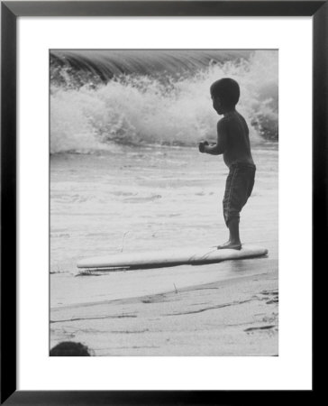 Little Boy Standing On A Surf Board Staring At The Water by Allan Grant Pricing Limited Edition Print image