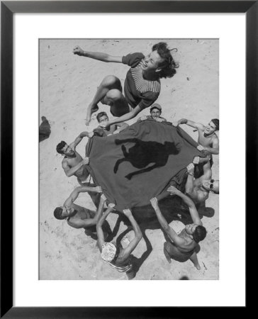 Teenaged Boys Using Blanket To Toss Their Friend, Norma Baker, Into The Air On The Beach by John Florea Pricing Limited Edition Print image