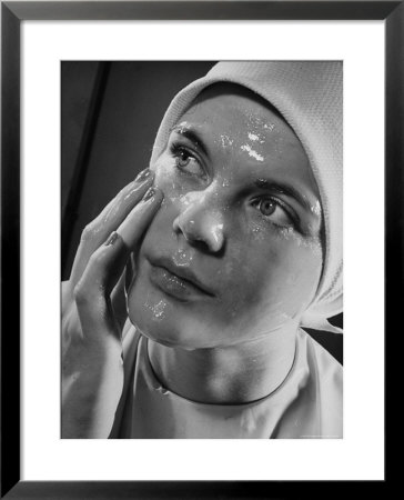 Woman Rubbing A Moist, Shiny Beauty Care Product On Her Face by George Karger Pricing Limited Edition Print image