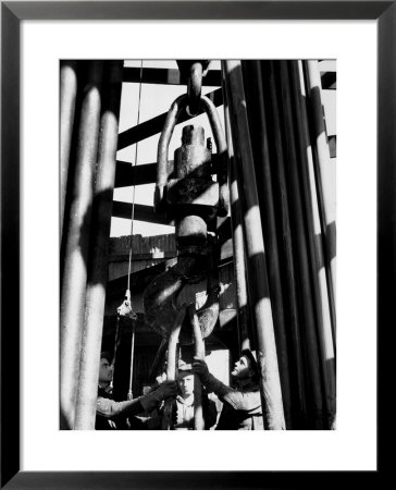Workers Lower Pipe Into Oil Well Inside Rig In A Texaco Oil Field by Margaret Bourke-White Pricing Limited Edition Print image