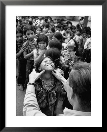Dr. Nevin S. Scrimshaw Of The Central American Institute Of Nutrition Examining Children For Goiter by Cornell Capa Pricing Limited Edition Print image