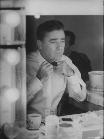 Actor Peter Lawford Using Dressing Room Mirror To Tie His Tie by John Loengard Pricing Limited Edition Print image