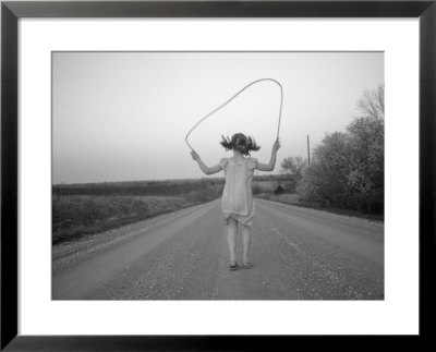 A Girl Jumps Rope Down A Gravel Road In Nebraska by Joel Sartore Pricing Limited Edition Print image