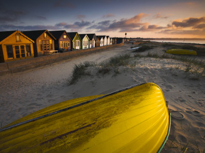 Beach Front Huts And Upturned Punt At Mudeford, Dorset, England by Adam Burton Pricing Limited Edition Print image