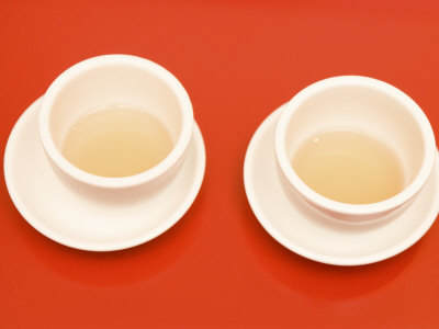 Close-Up Of Two Tea Cups On Red Table For Chinese Tea Ceremony by Images Monsoon Pricing Limited Edition Print image