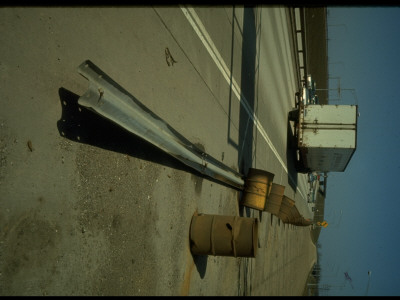 Dangerous Highway Situation: Line Of Rusted Barrels And Felled Guardrail Off Closed Exit Lane by Ralph Crane Pricing Limited Edition Print image