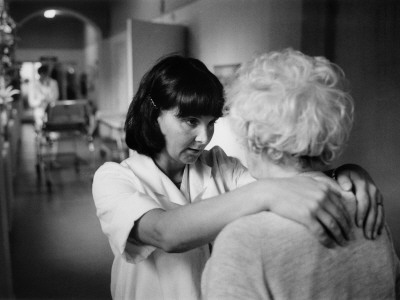A Nurse In A Nursing Home Talking Affectionately To A Senior Woman by Bengt-Goran Carlsson Pricing Limited Edition Print image