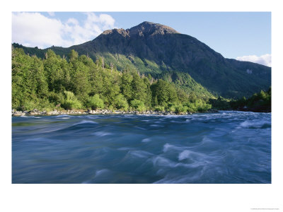 A Mountain Peak Looms Over The Aqua Water Of The Futaleufu River by Skip Brown Pricing Limited Edition Print image