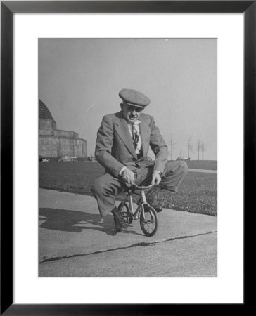 Humorous Of Man Riding Tiny Bicycle by Wallace Kirkland Pricing Limited Edition Print image