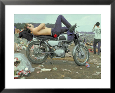 Shirtless Man In Levi Strauss Jeans Lying On Motorcycle Seat At Woodstock Music Festival by Bill Eppridge Pricing Limited Edition Print image