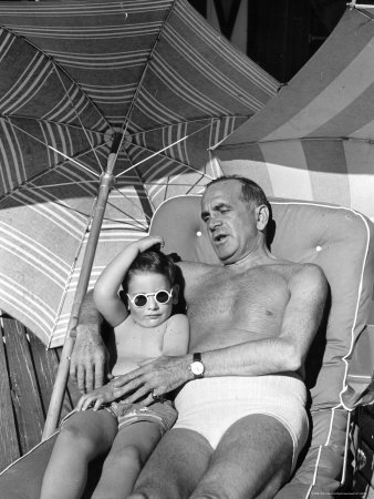 Singer Al Jolson With Young Son Al Jr, Sharing Lounge Chair While Enjoying The Sun On The Beach by Alfred Eisenstaedt Pricing Limited Edition Print image