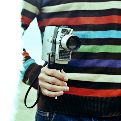 A Young Man Holding An Old Cine Camera by Jewgeni Roppel Pricing Limited Edition Print image