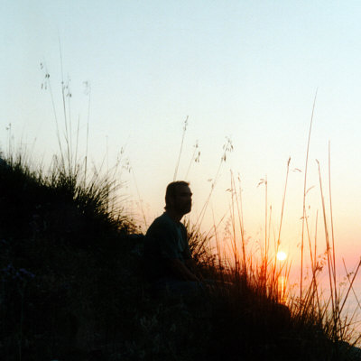 Man Sitting On Hillside At Sunrise by Ilona Wellmann Pricing Limited Edition Print image