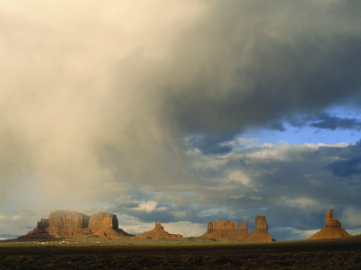 Evening Clouds Filter Light Over The Buttes Of Monument Valley by Stephen St. John Pricing Limited Edition Print image