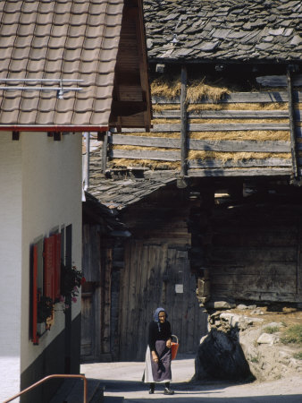 Elderly Woman With A Bucket Walks Past Traditional Farm Buildings by Thomas J. Abercrombie Pricing Limited Edition Print image