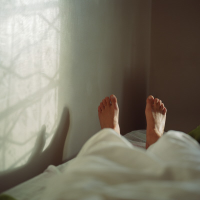 Close-Up Of A Person's Feet With Shadow On The Wall by Lo Birgersson Pricing Limited Edition Print image