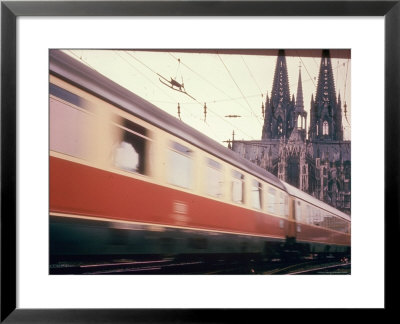 Eurailpass In Europe: Germany's Parsifal Express Speeding Past Cologne Cathedral by Carlo Bavagnoli Pricing Limited Edition Print image