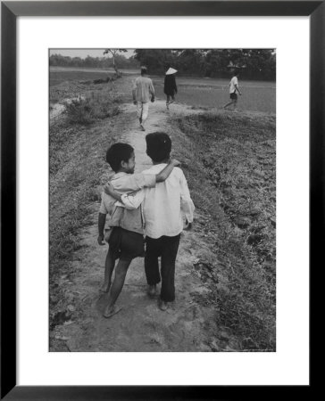Vietnamese Farm People Walking On Raised Path Between Rice Paddies by John Dominis Pricing Limited Edition Print image