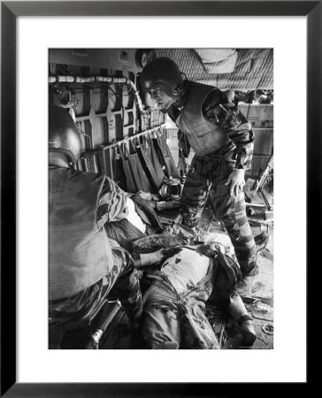 Helicopter Crew Chief James C. Farley With Wounded Pilot Lt. James Magel Lays Dying At His Feet by Larry Burrows Pricing Limited Edition Print image