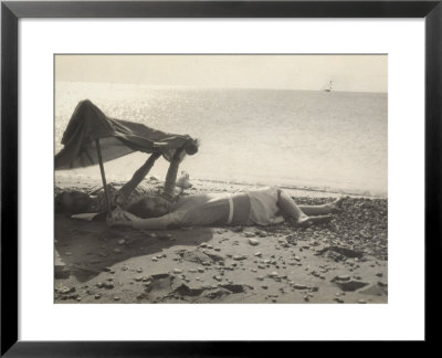 Two Women Lying On The Sea Shore In The Shade Of A Towel by Ludovico Pacho Pricing Limited Edition Print image